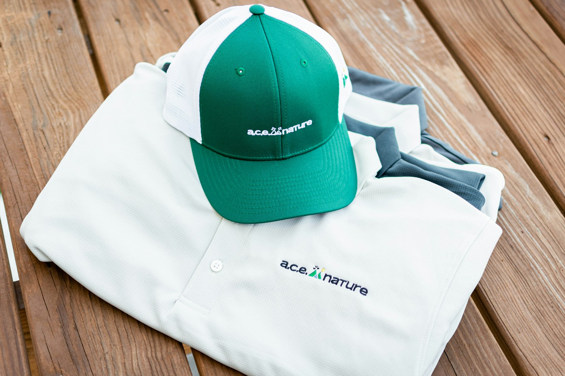 Embroidered cap resting on a folded embroidered polo shirt