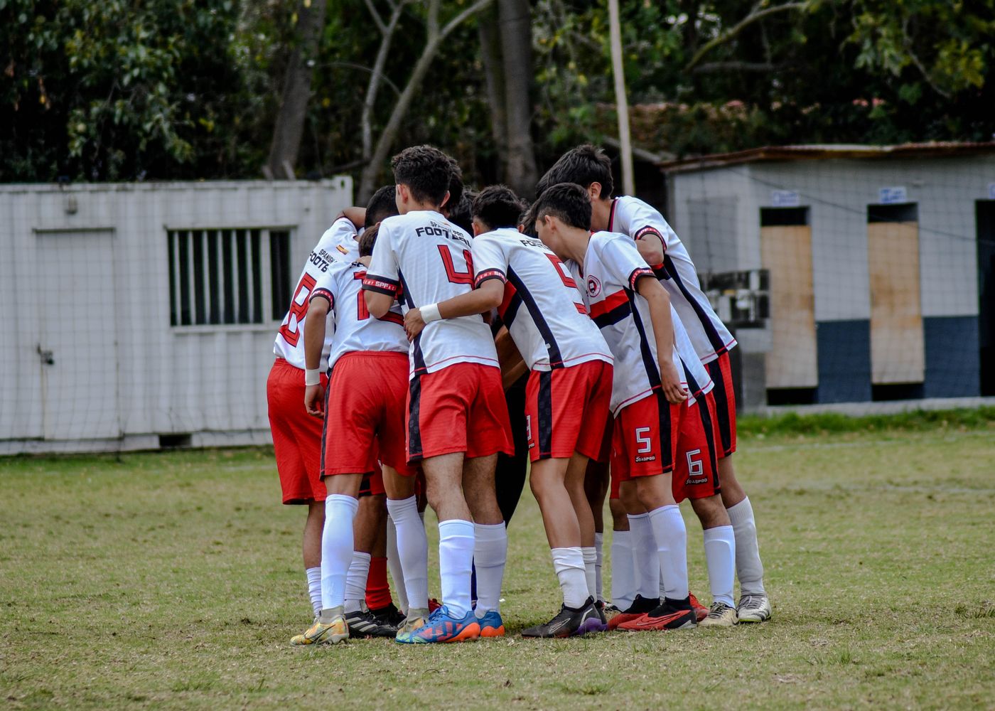 Youth team wearing matching uniforms in a pregame huddle
