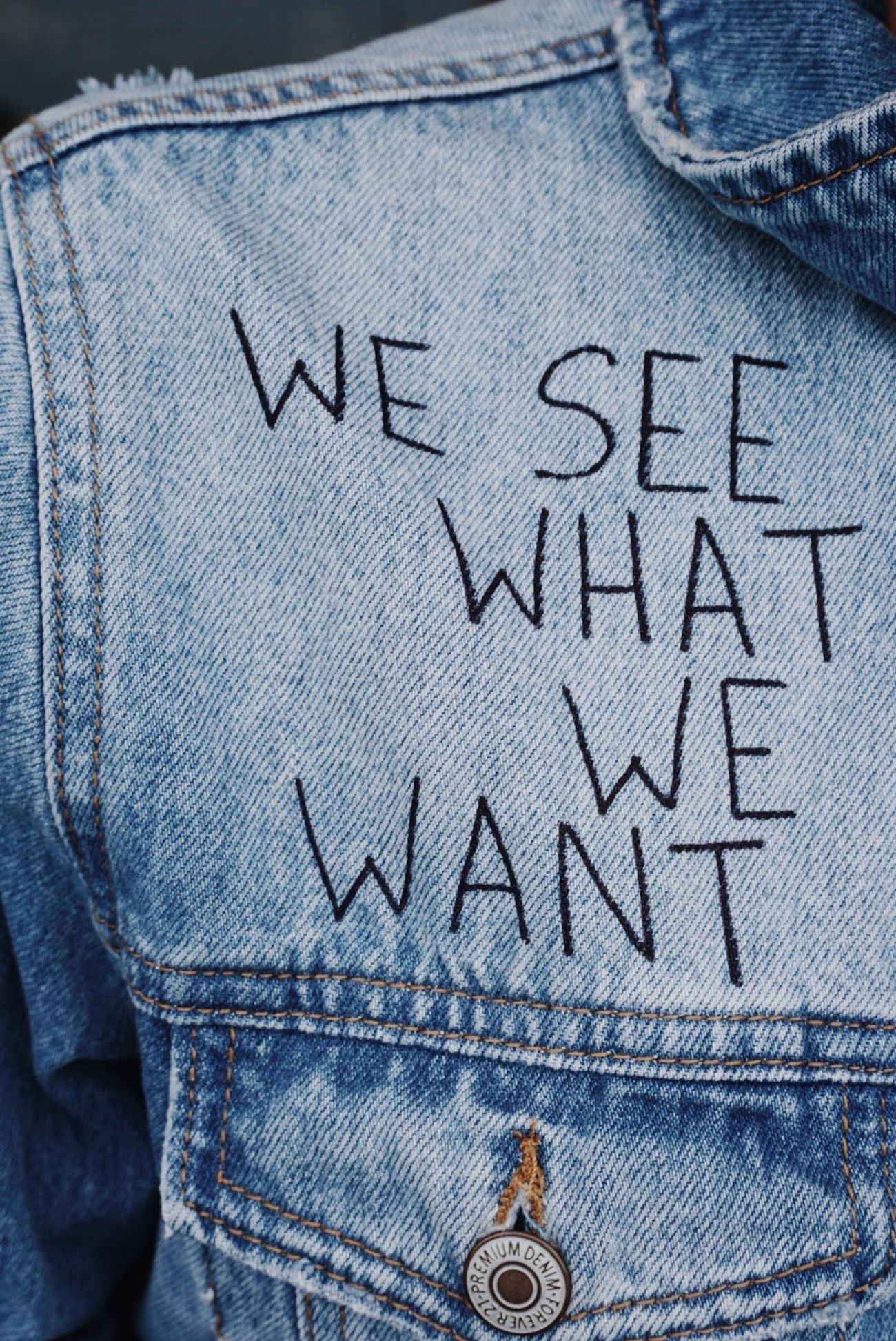 Close-up of stitched lettering on a denim jacket