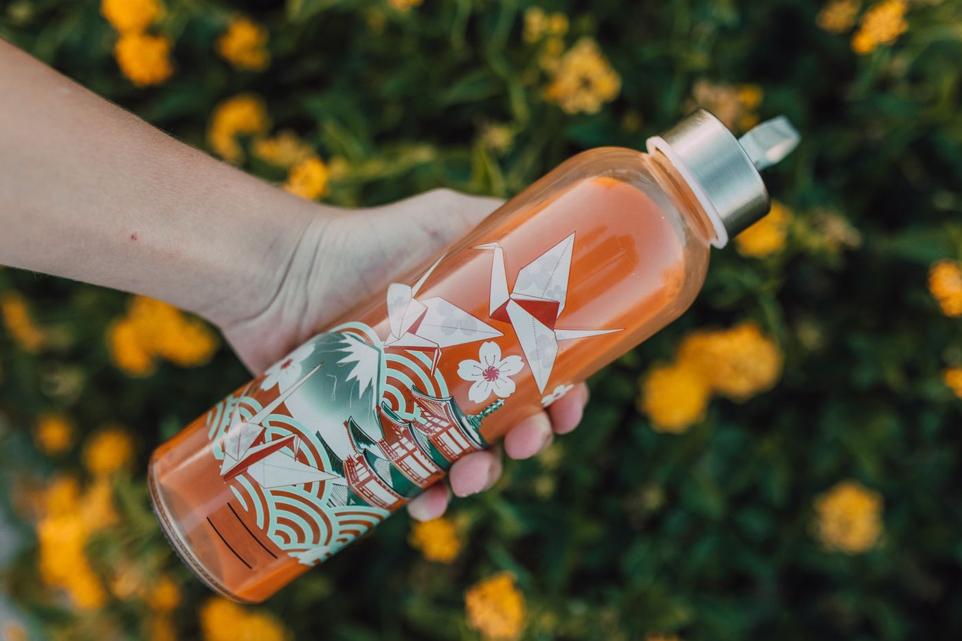Printed reusable drink bottle being carried outdoors