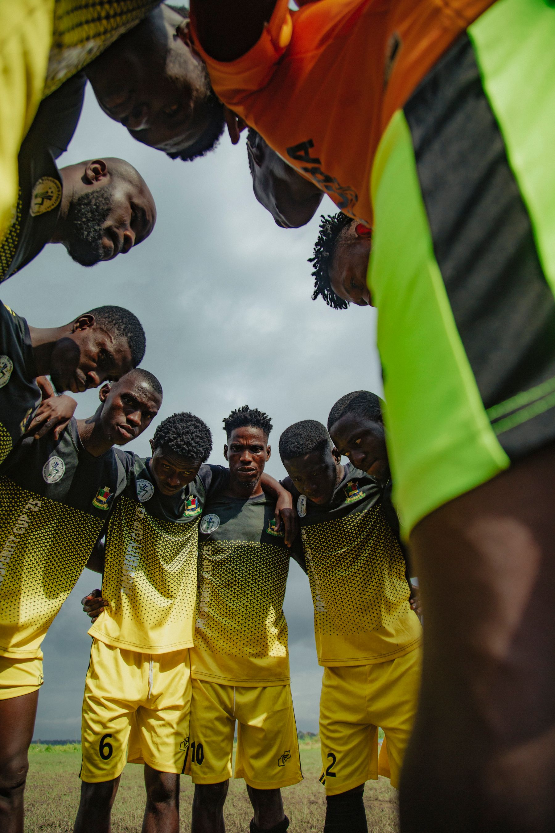 Sports team in modern coordinated jerseys gathered in a huddle